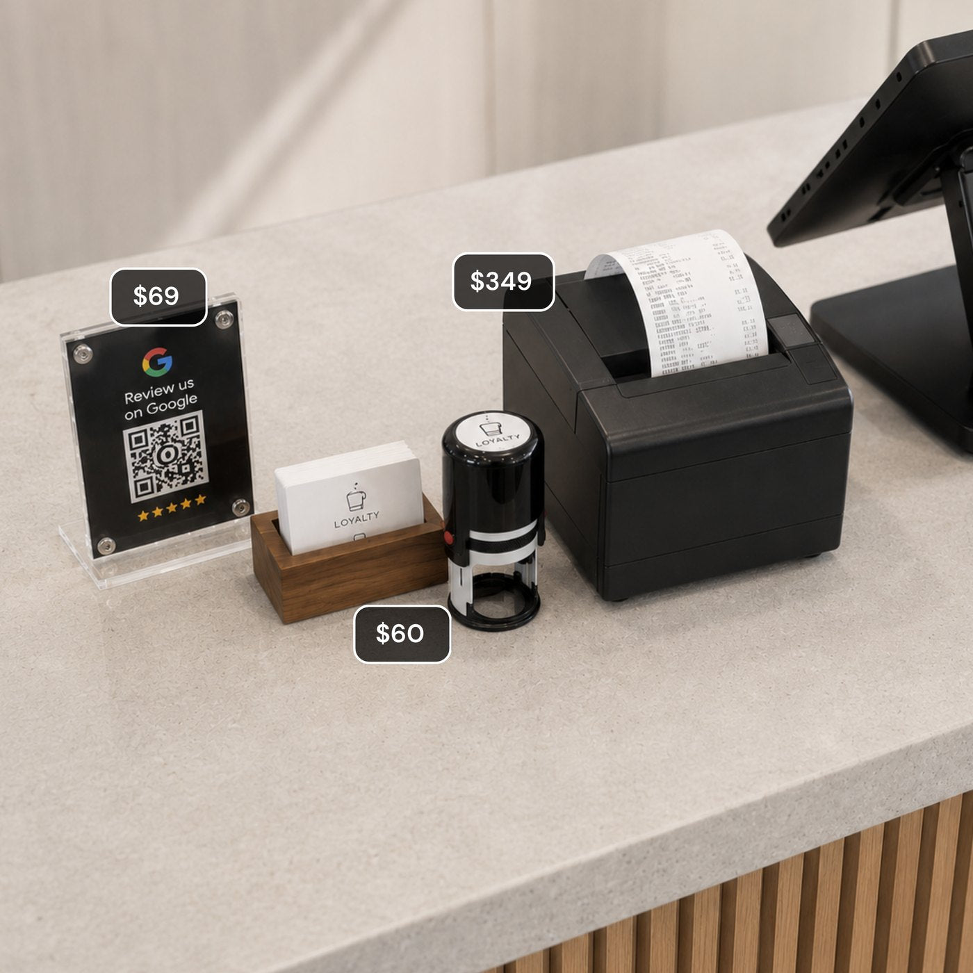A counter cluttered with a receipt printer, loyalty stamp and review stand, each with its price